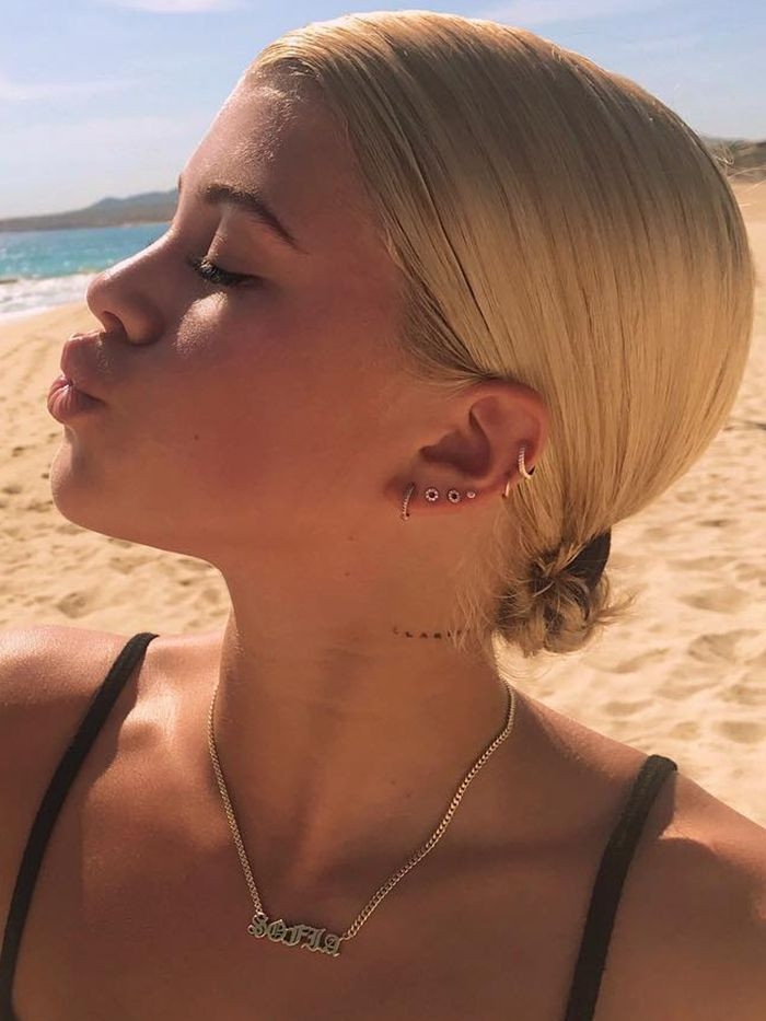 Sophie Richie's neck tattoo, a testament to the understated impact of dainty lettering tattoos, ideal for those seeking subtle yet meaningful personal statements.