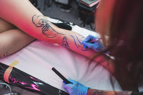 Close-up of a hand-poked tattoo featuring a minimalist black ink design, highlighting the unique texture and subtle variations in ink distribution characteristic of this tattooing method