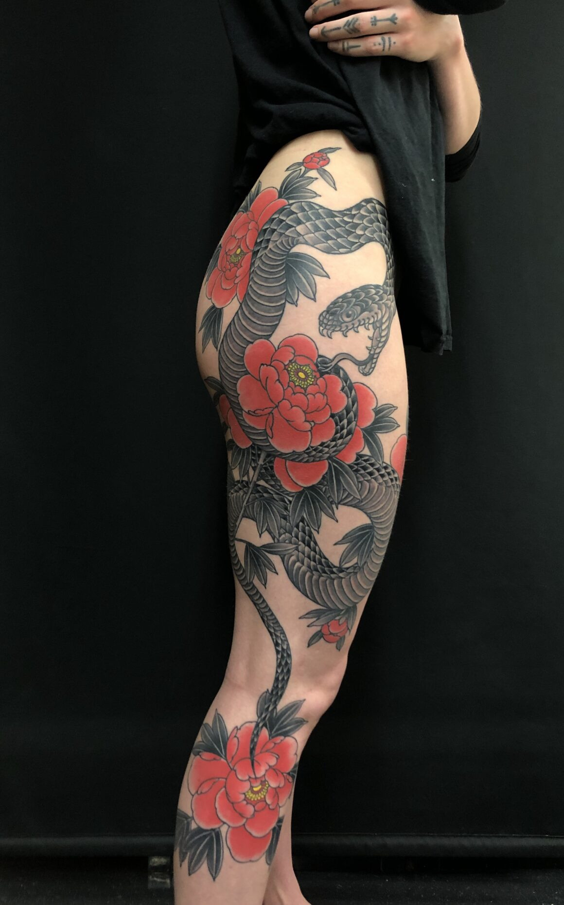 Rodrigo Souto's tattoo art features a stunning portrayal of Japanese peonies, demonstrating his attention to detail and skill in floral designs