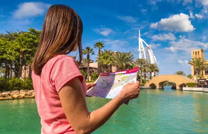 A person in Dubai carefully covering their arm tattoo with a long sleeve, illustrating the need for discretion in public.