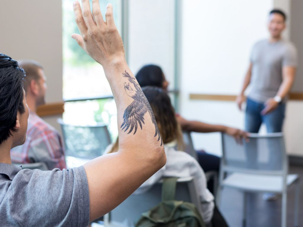 Teacher with tattoo asking question