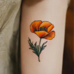 Woman with California poppy tattoo on her arm